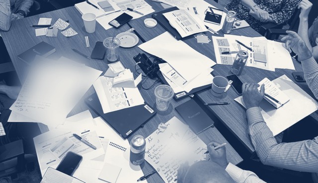 Notes, sketches and prompts spread across a table mid-session